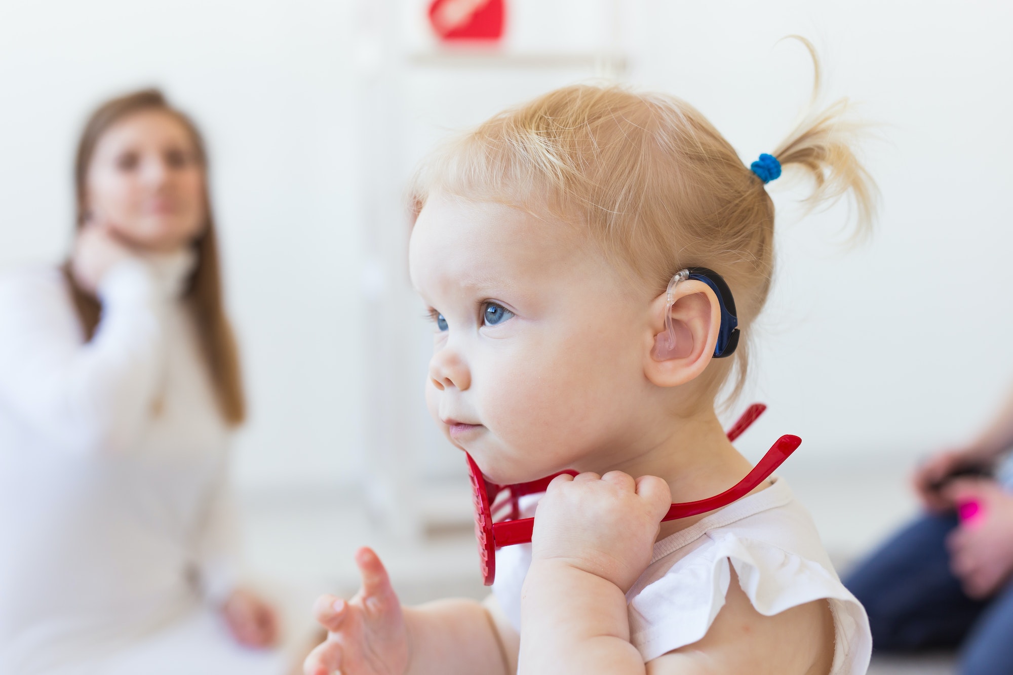 Baby girl wearing a hearing aid. Disabled child, disability and deafness concept