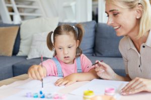 Disabled girl painting with mother