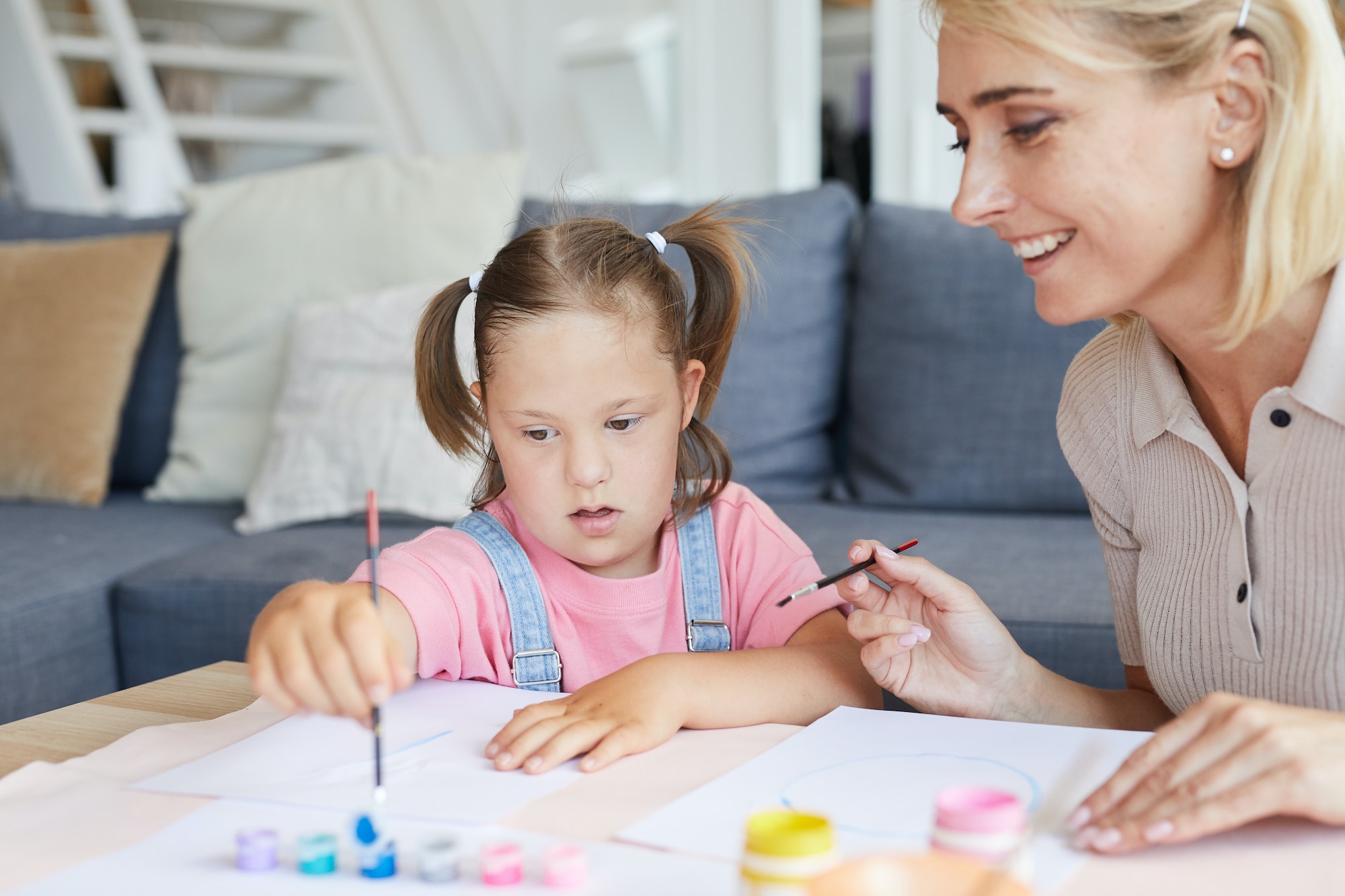 Disabled girl painting with mother